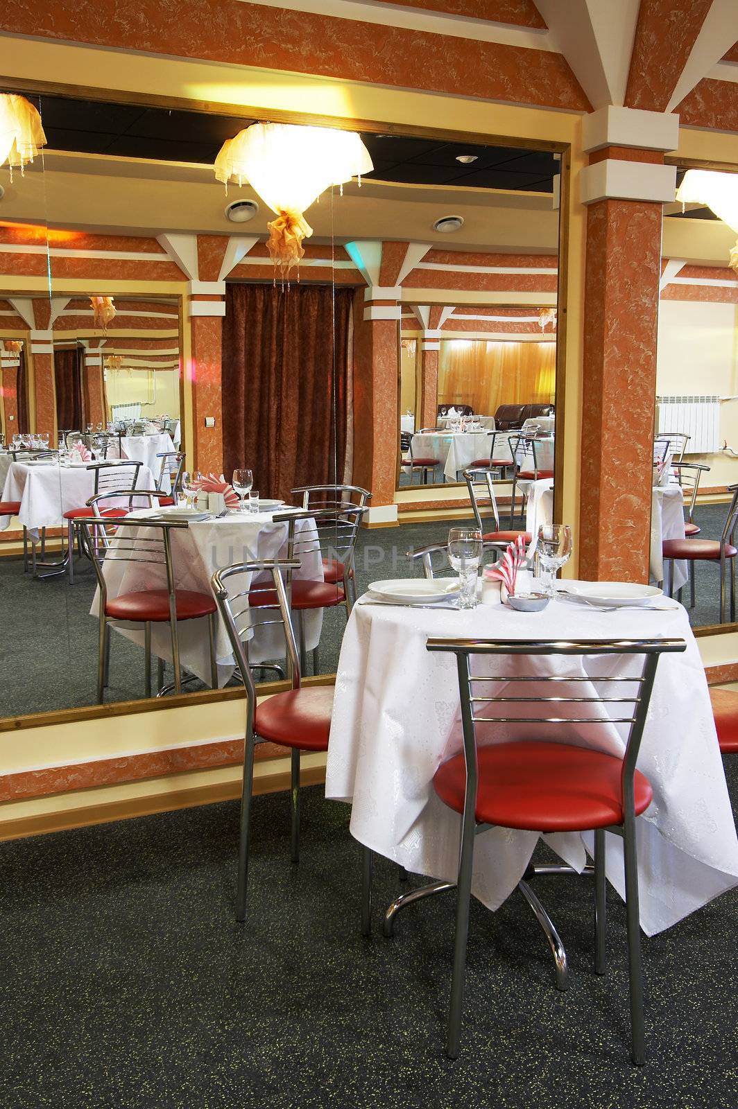 Tables, chairs and mirrors at modern restaurant