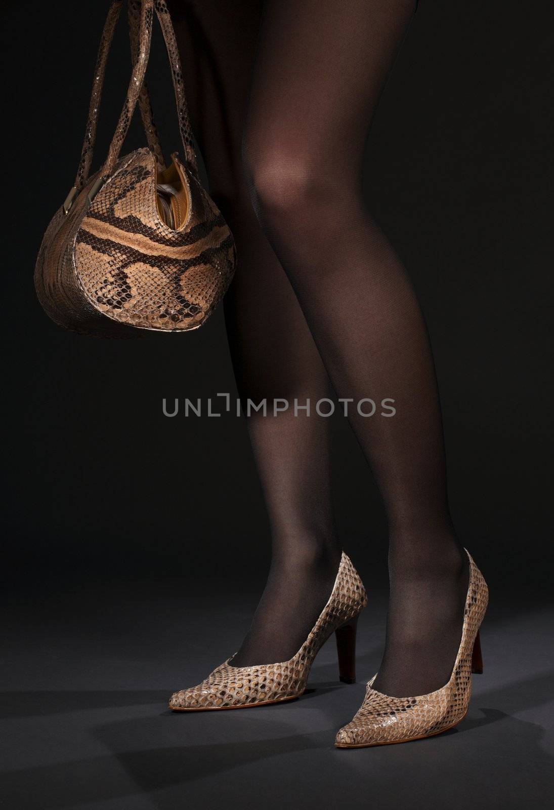 long legs in snakeskin shoes with handbag over black