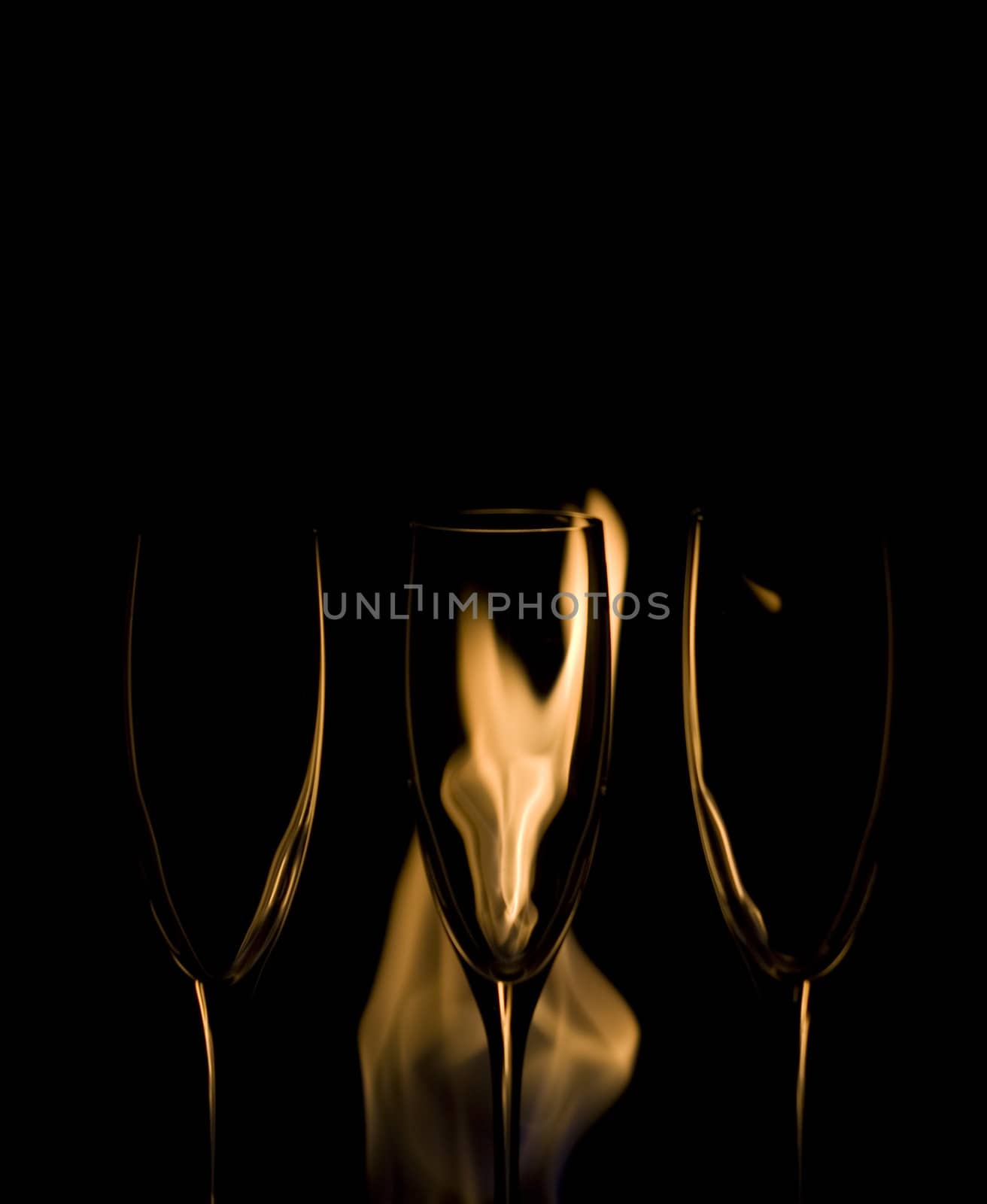 Three Crystal glasses and fire isolated on black  