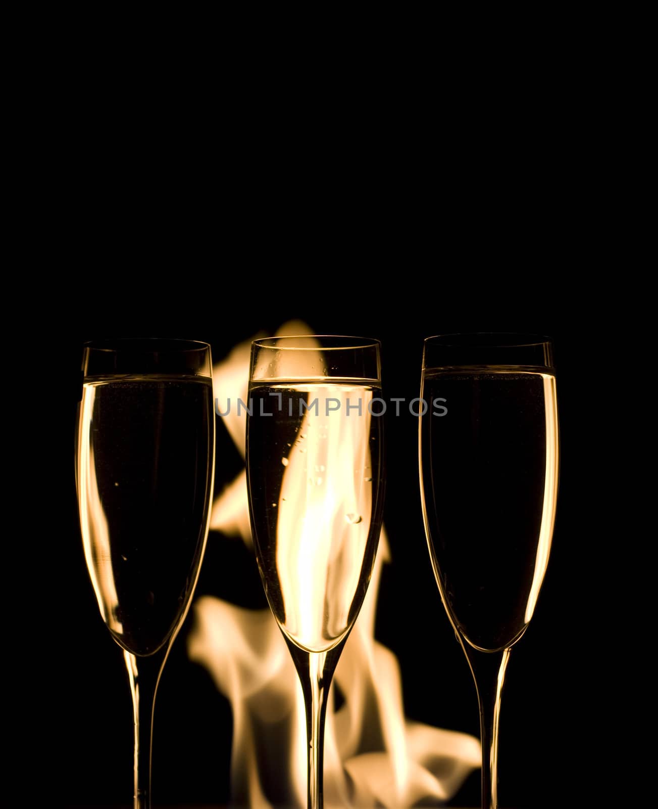 Three Crystal glasses and fire isolated on black  