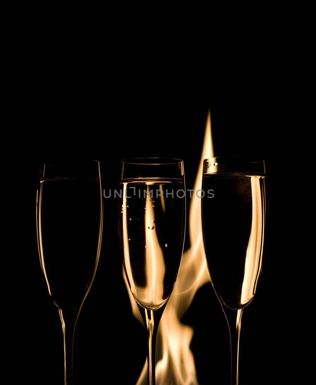 Three Crystal glasses and fire isolated on black  