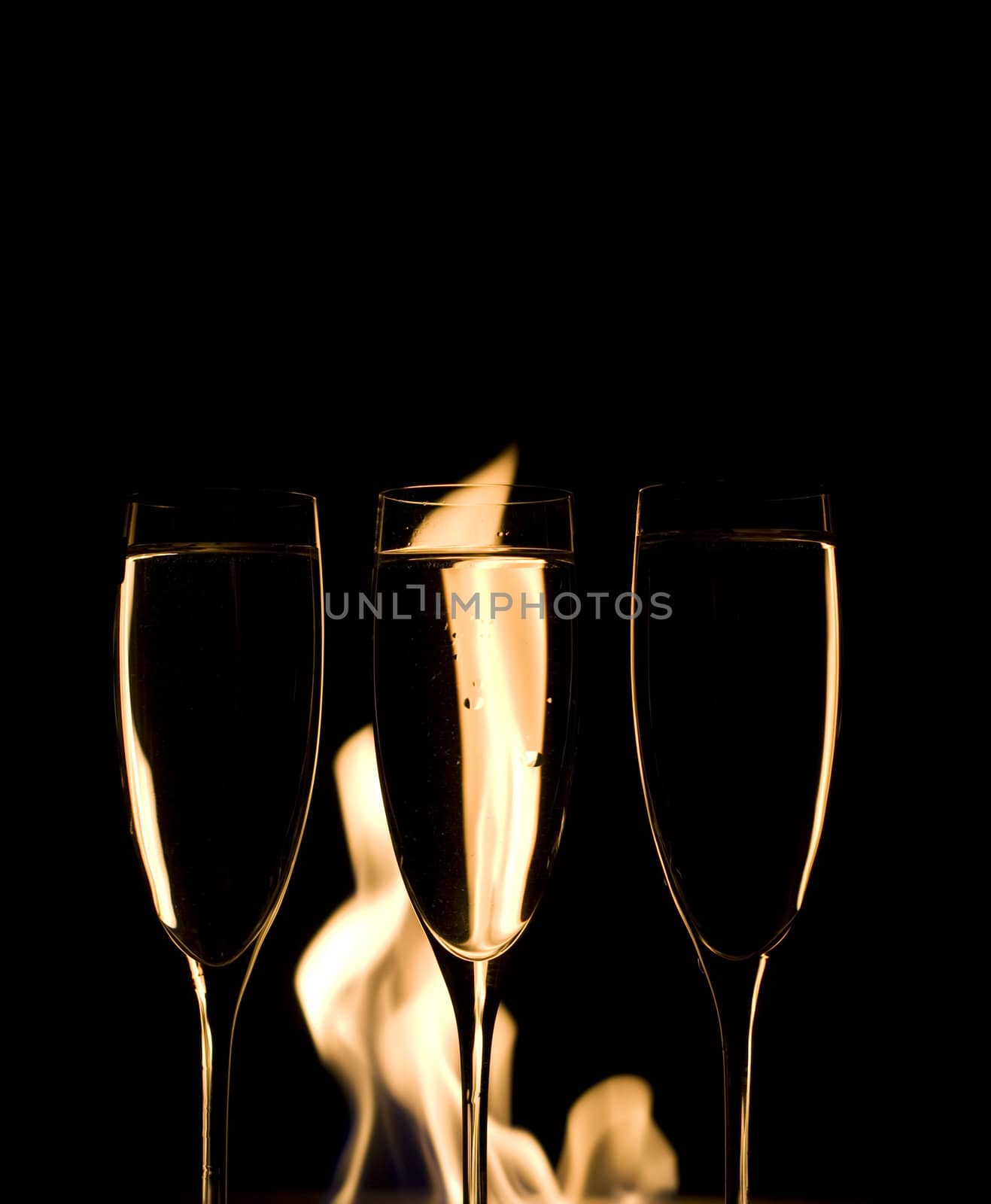 Three Crystal glasses and fire isolated on black  