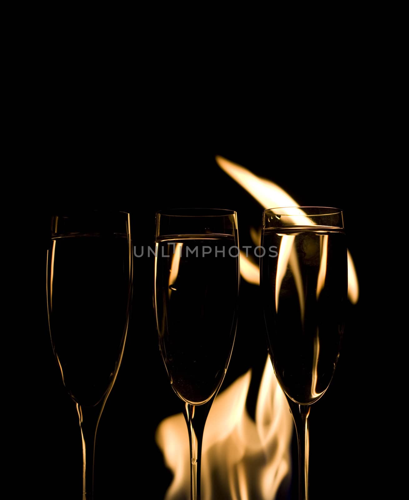 Three Crystal glasses and fire isolated on black  