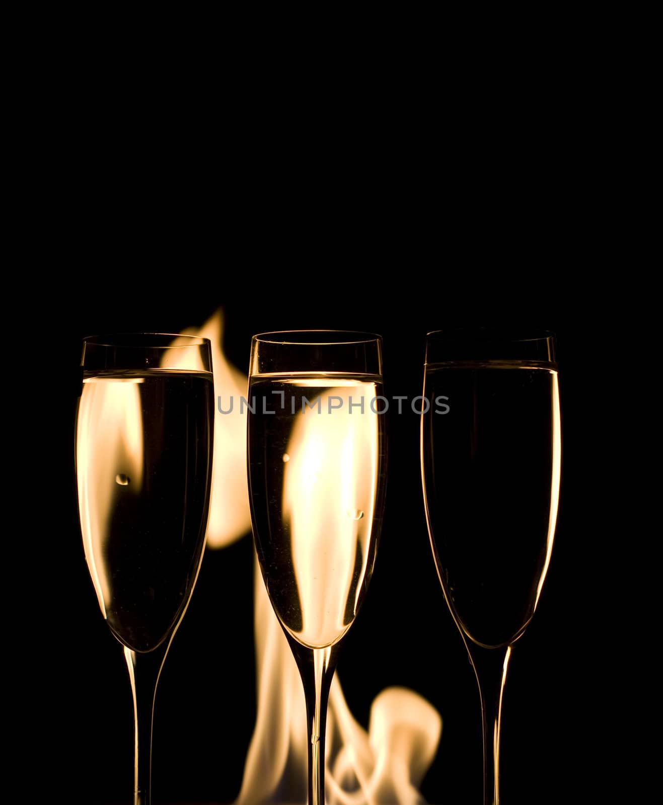 Three Crystal glasses and fire isolated on black  