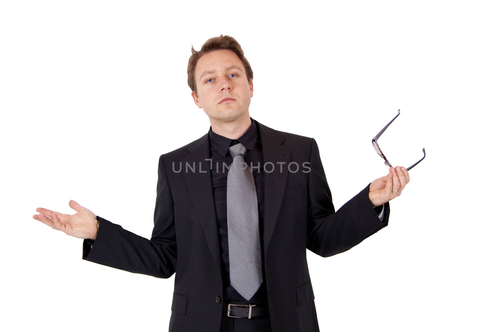 A young business man is holding his glasses while presenting something