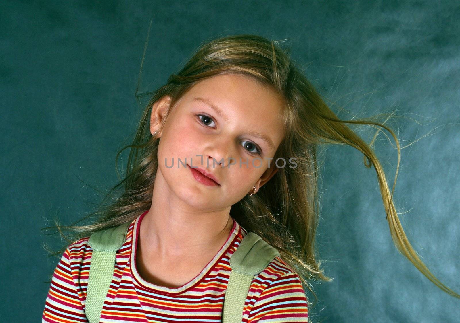 Portrait of the girl with fluttering hair on a dark blue background