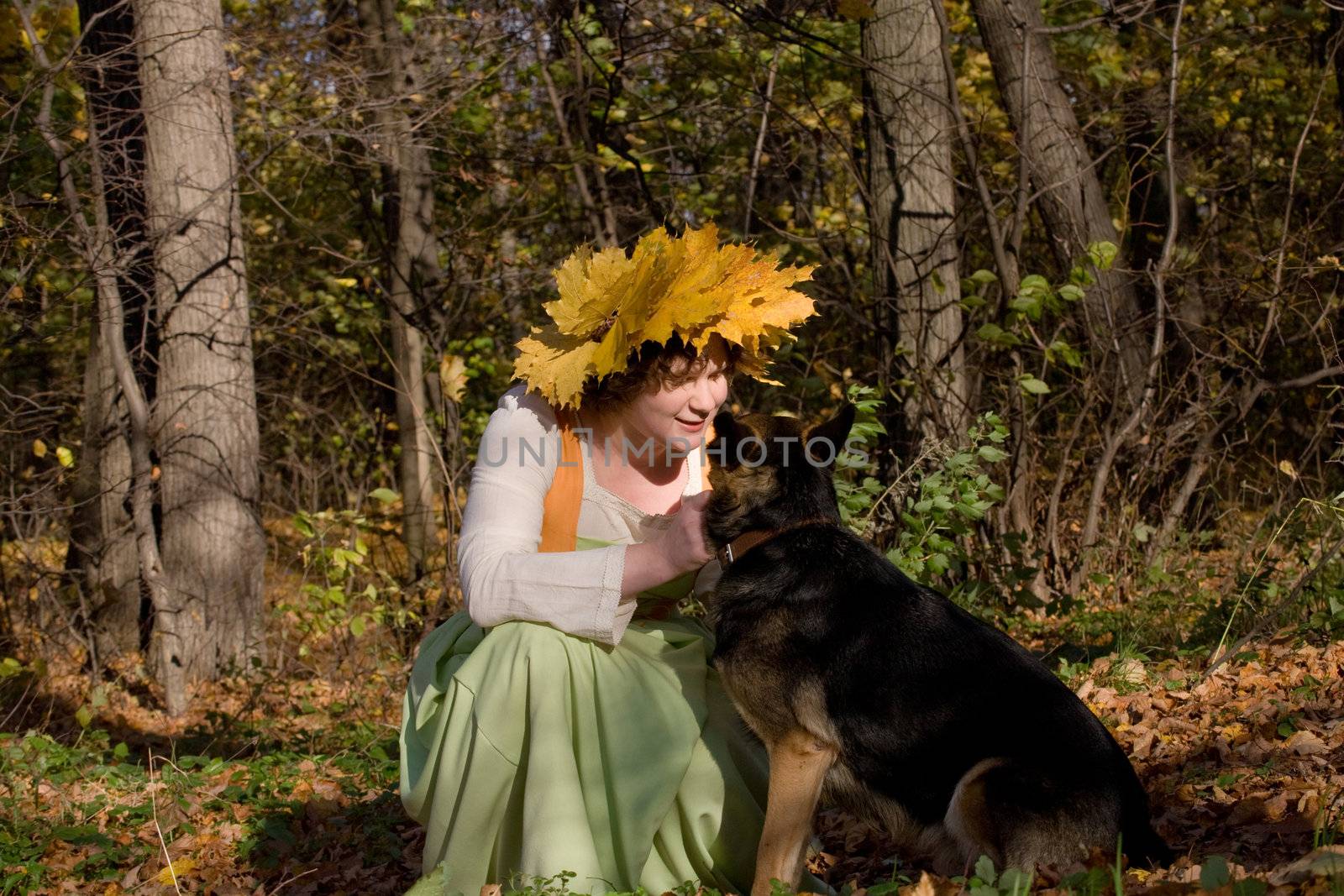 Woman and dog in autumn forest
