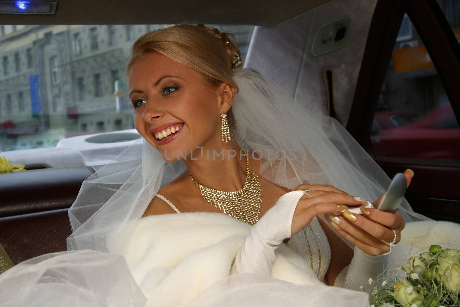 The beautiful bride in the automobile. The happy Bride.