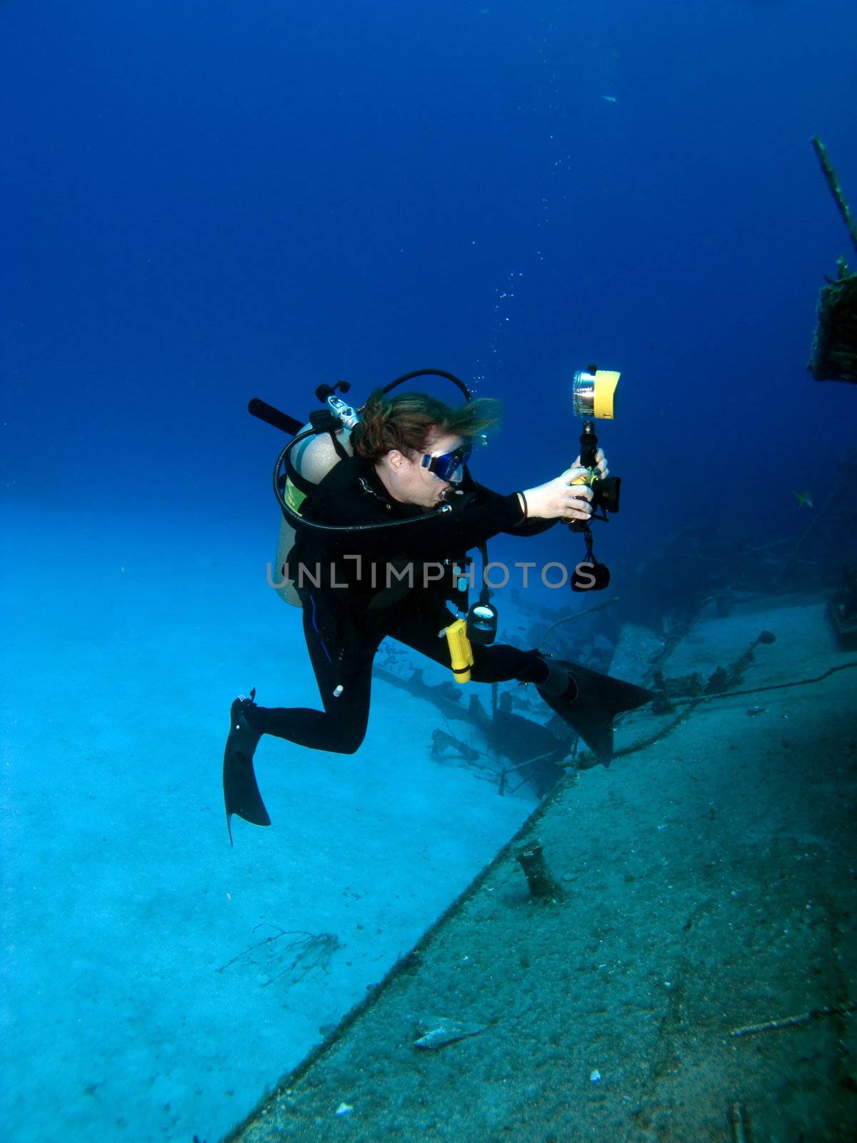 A Female Professional Underwater Photographer shooting the MV Tibbetts in Cayman Brac