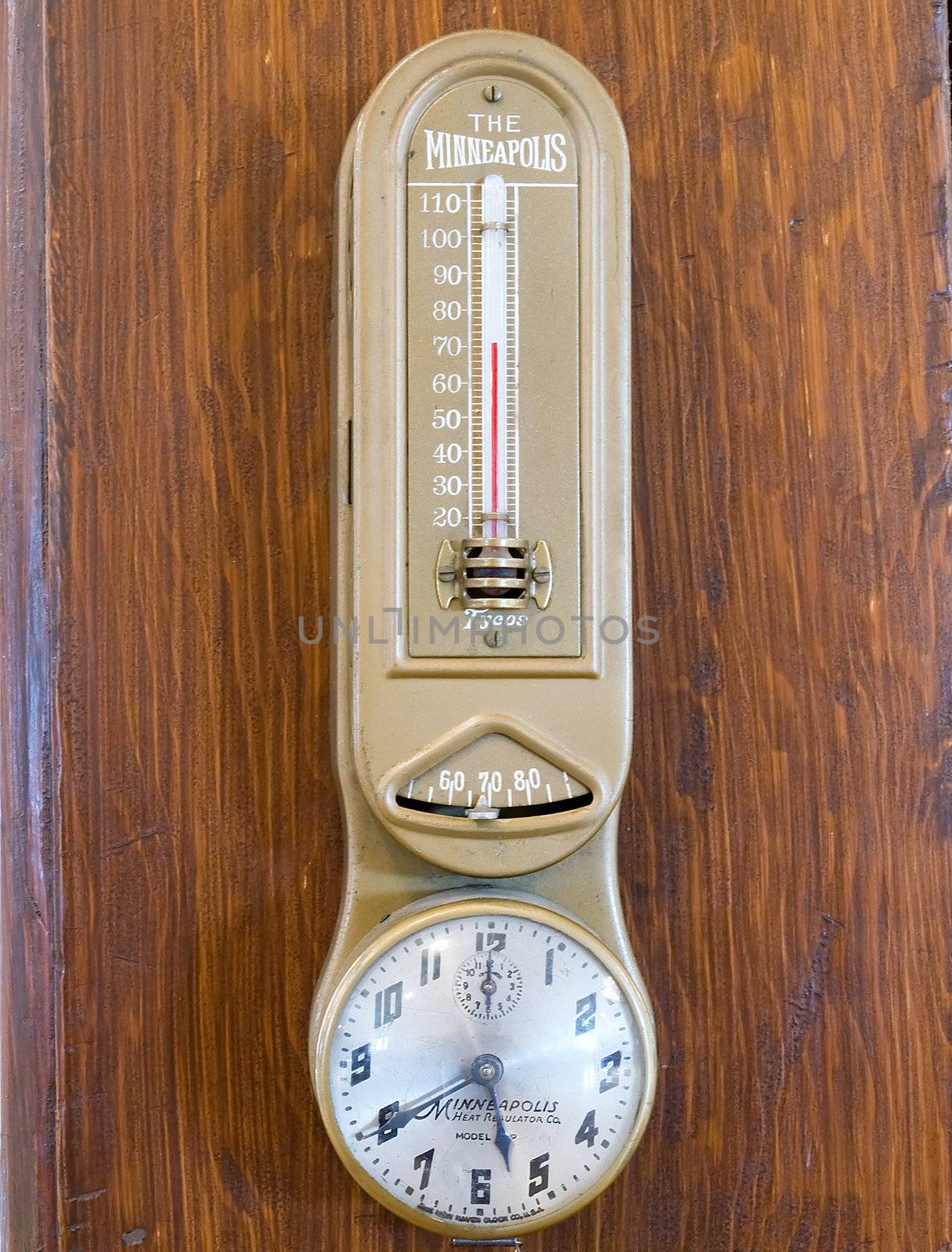 Very old thermometer hanging on a wooden post.