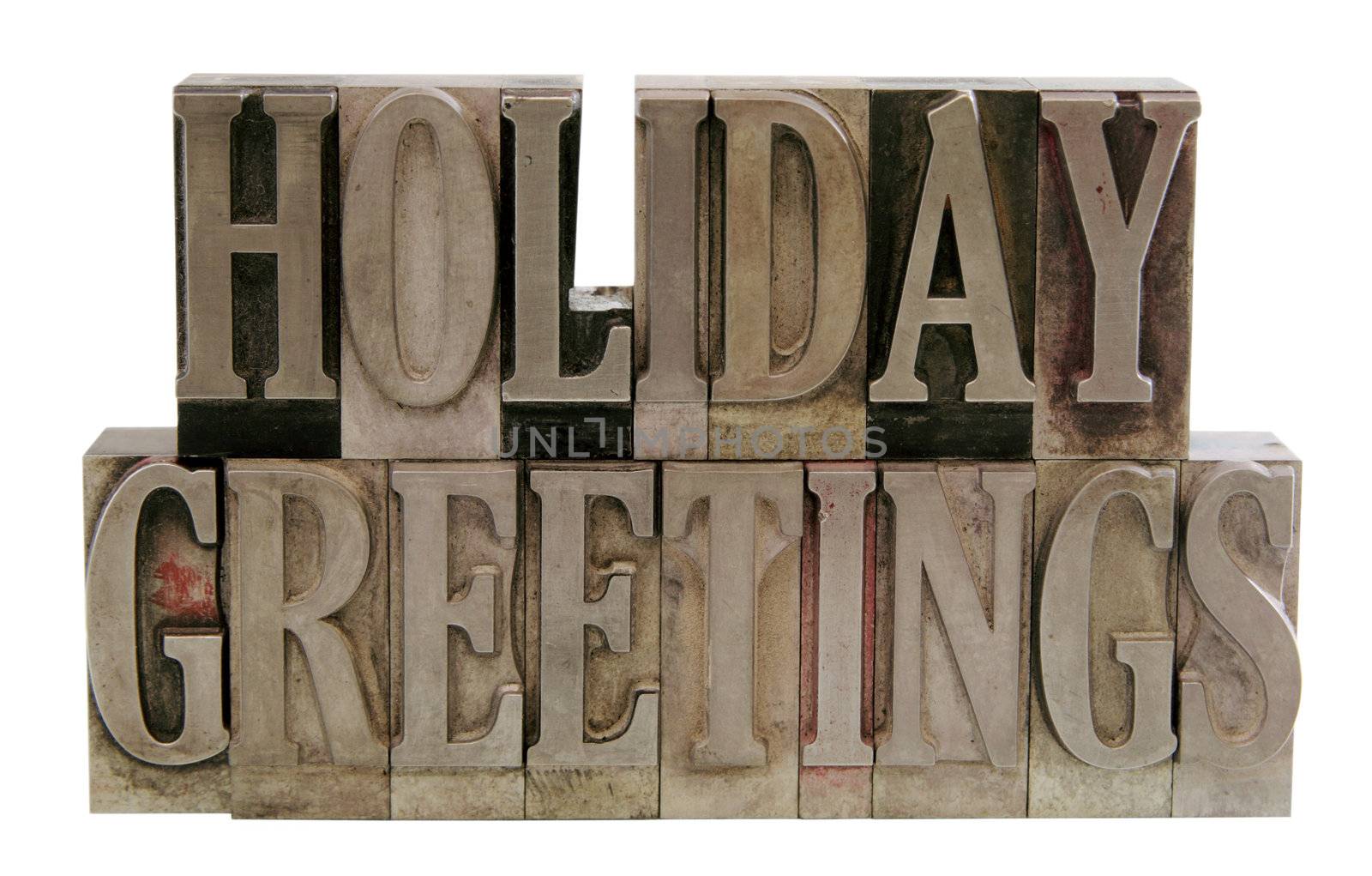 the words 'holiday greetings' in old lead letterpress type isolated on white
