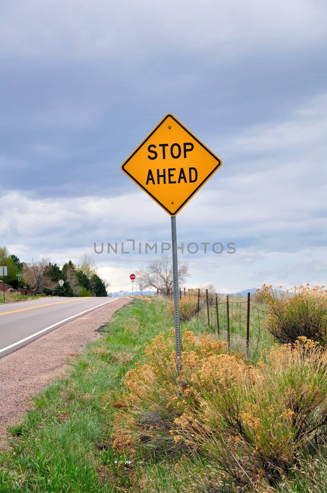 A traffic sign stands along a street in rural America.