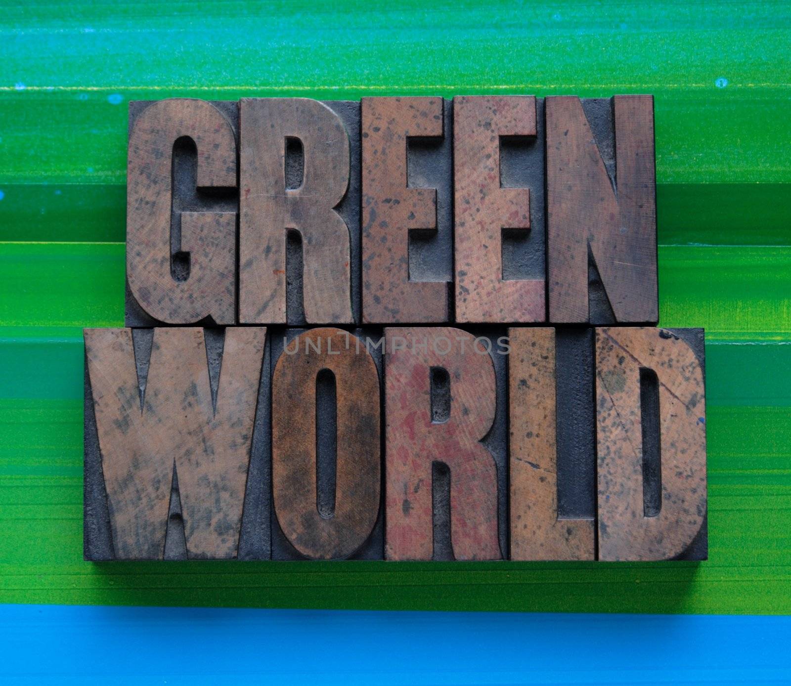 the words 'green world' in letterpress wood type on a green and blue background