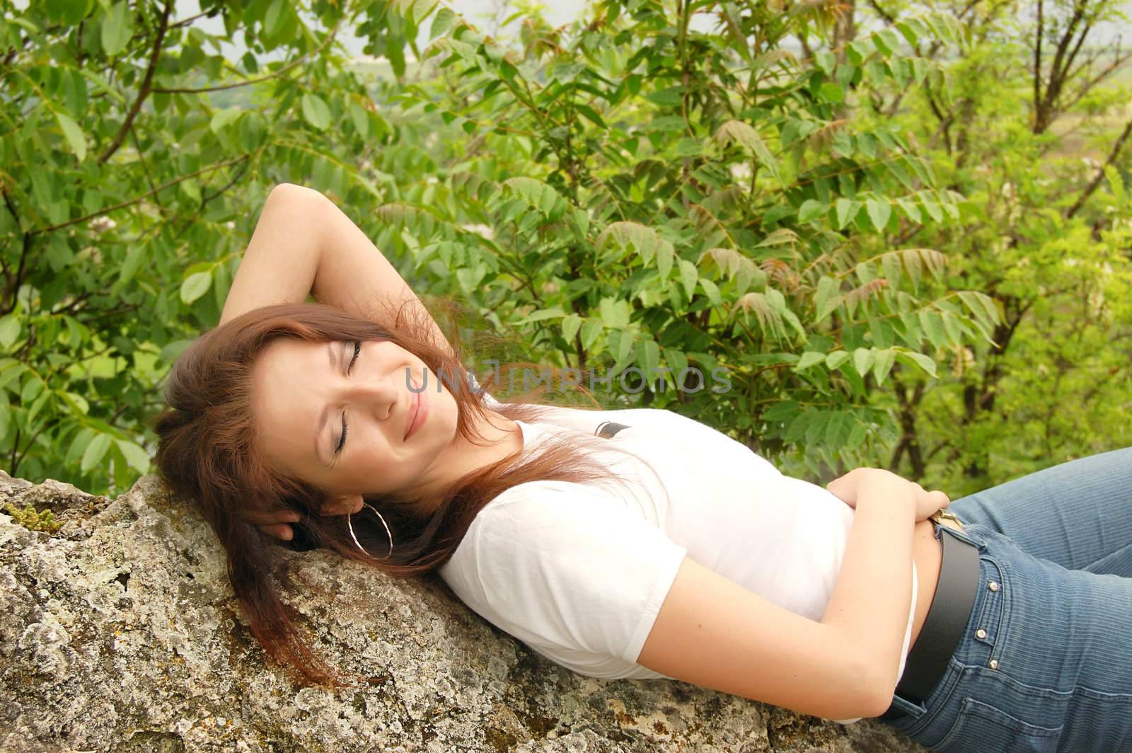 beautiful girl lying on rocks enjoying sun