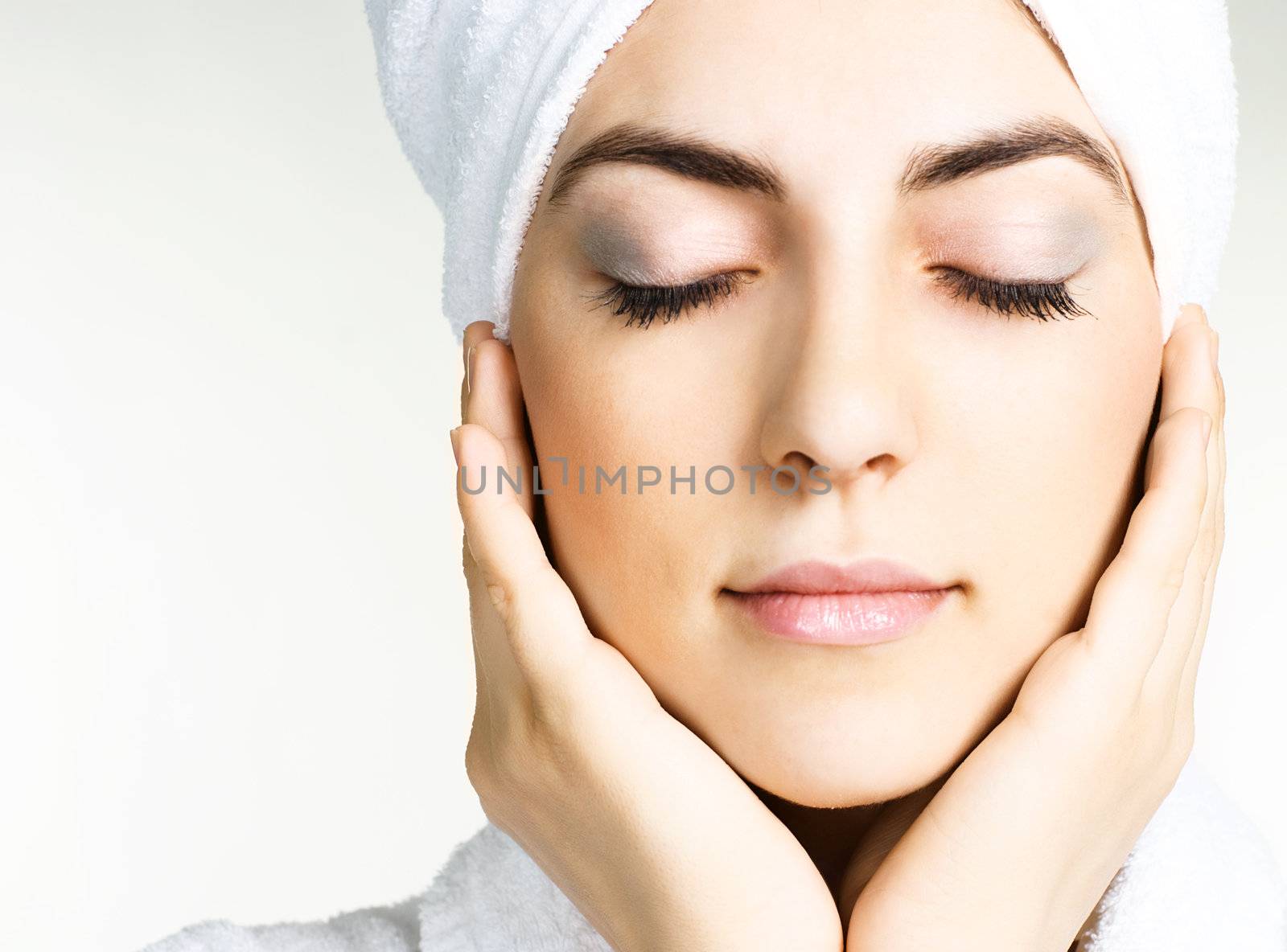 portrait of a pretty girl wrapped into the white towel with her eyes closed