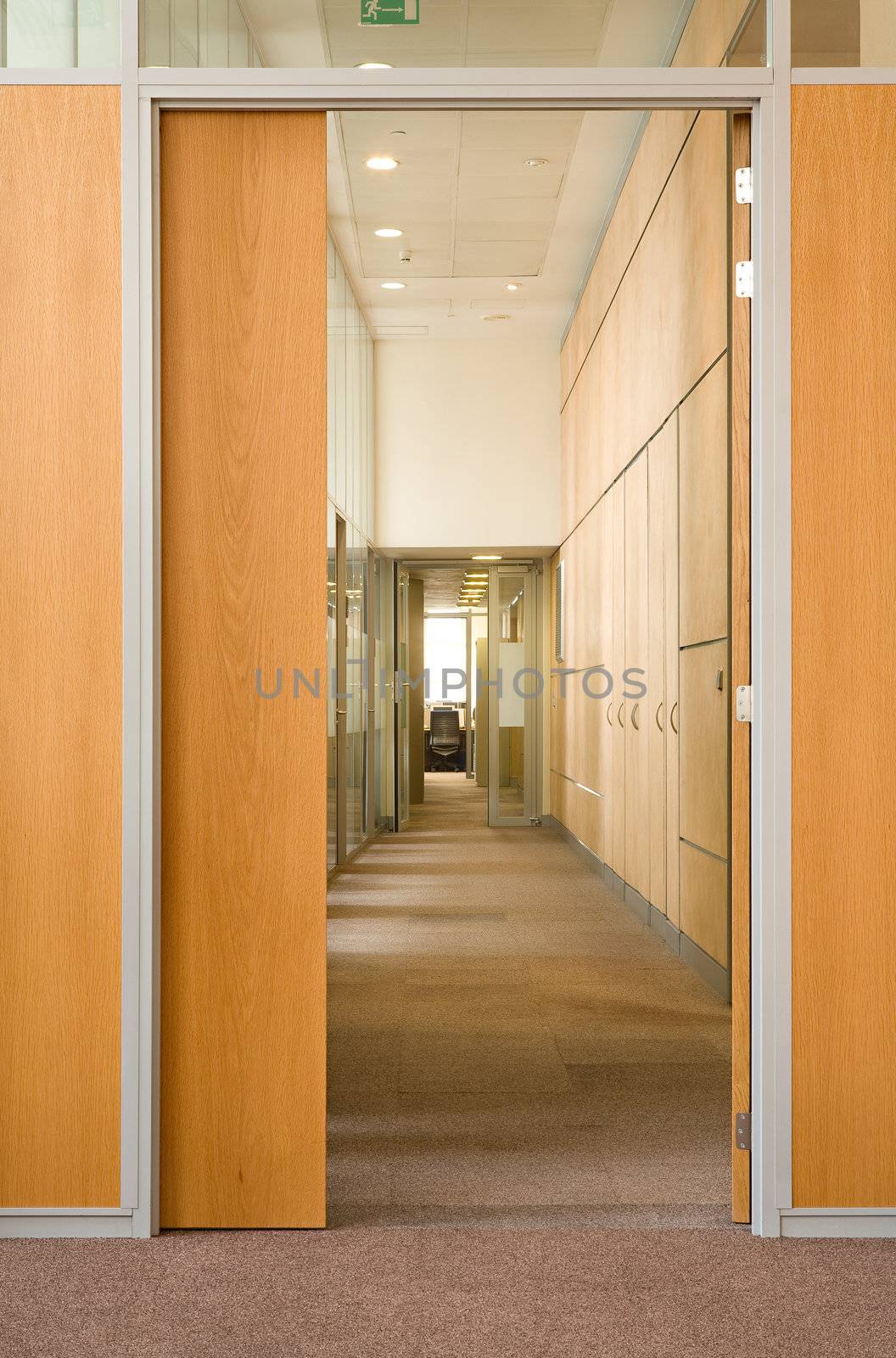 The open door in a long corridor in which other open doors in office centre are visible

