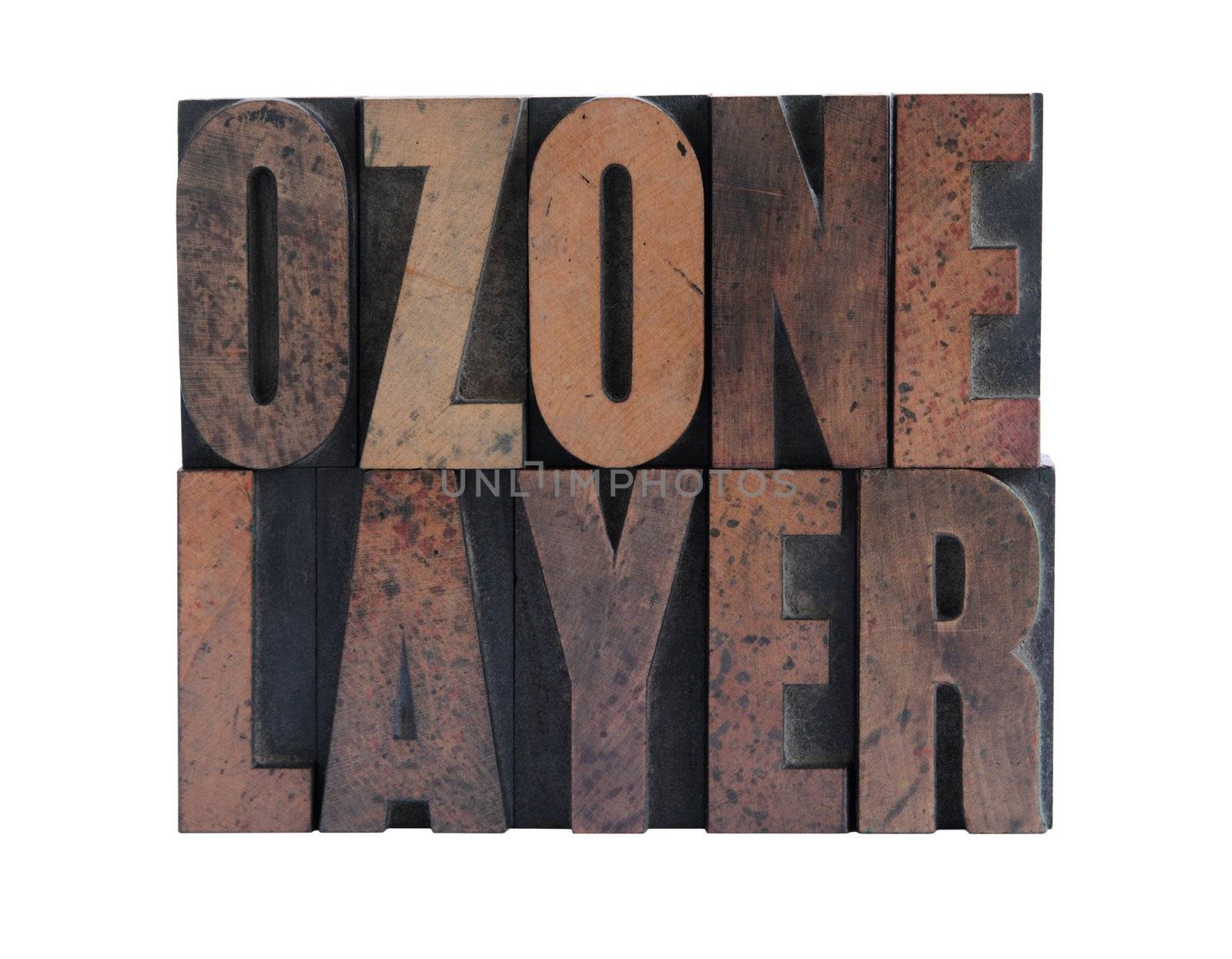 the phrase 'ozone layer' in ink-stained wood letters isolated on white