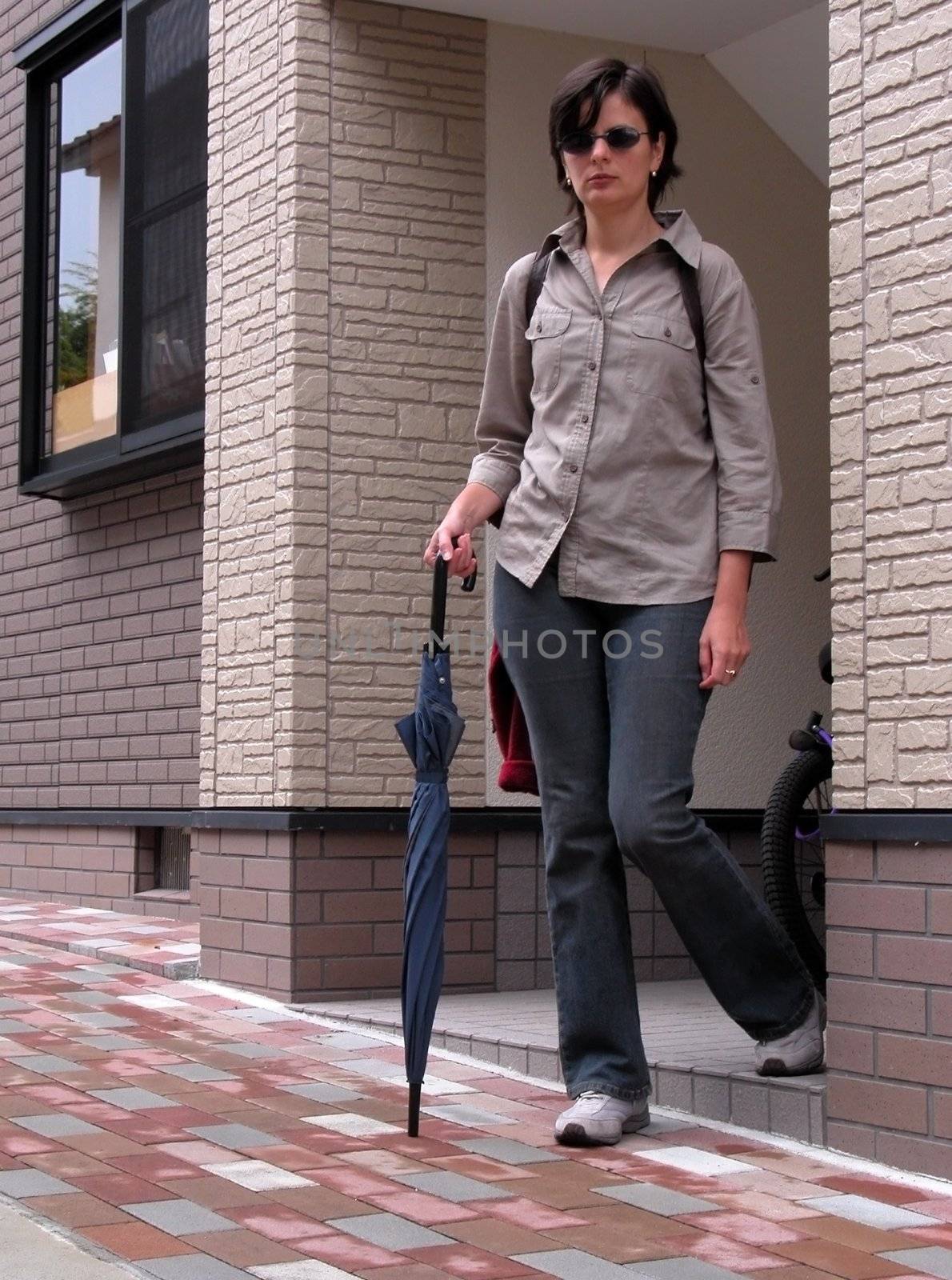 Woman wih umbrella living the house          