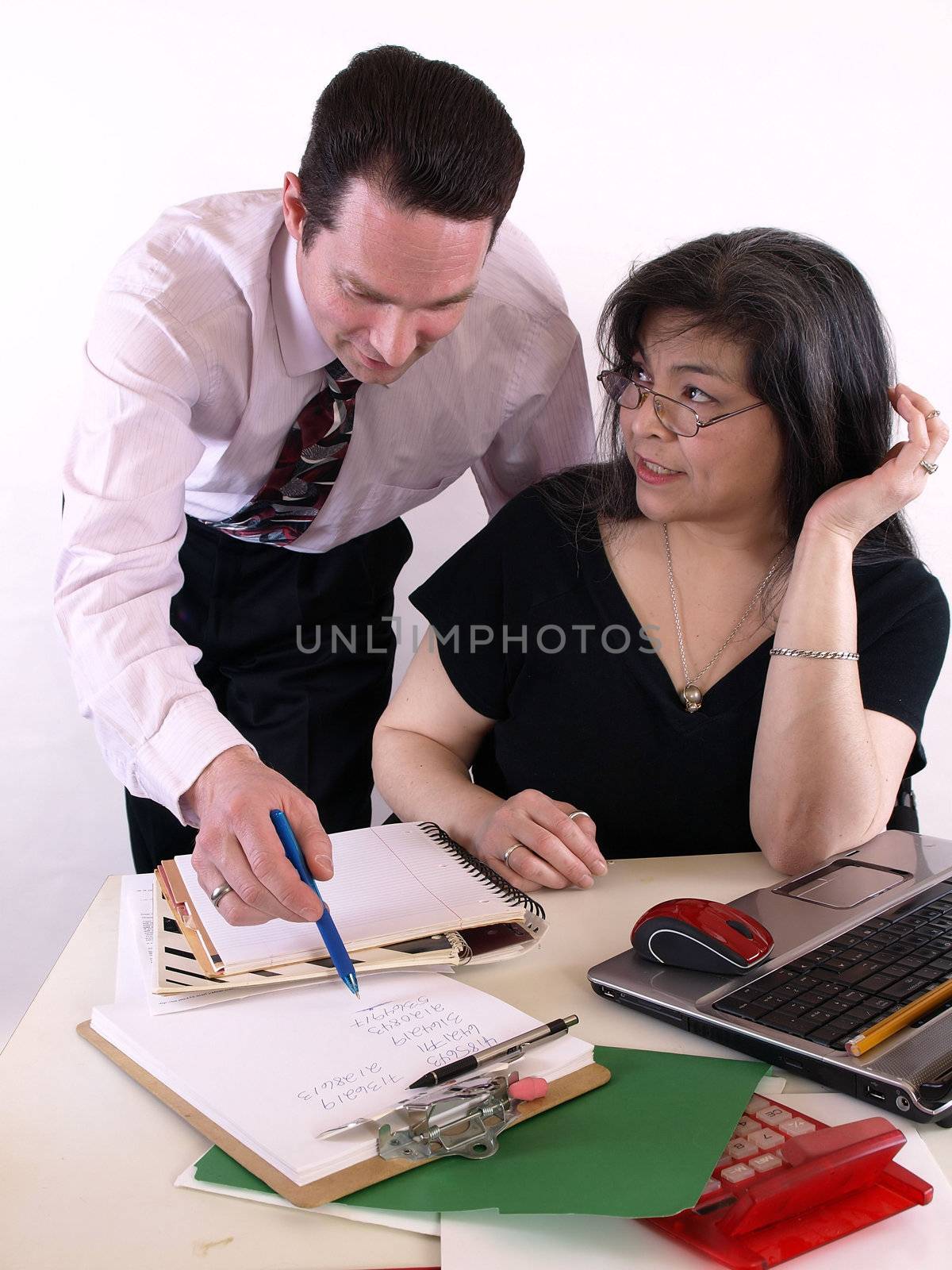 A male and female working together in the office at the computer. Isolated against a white background.