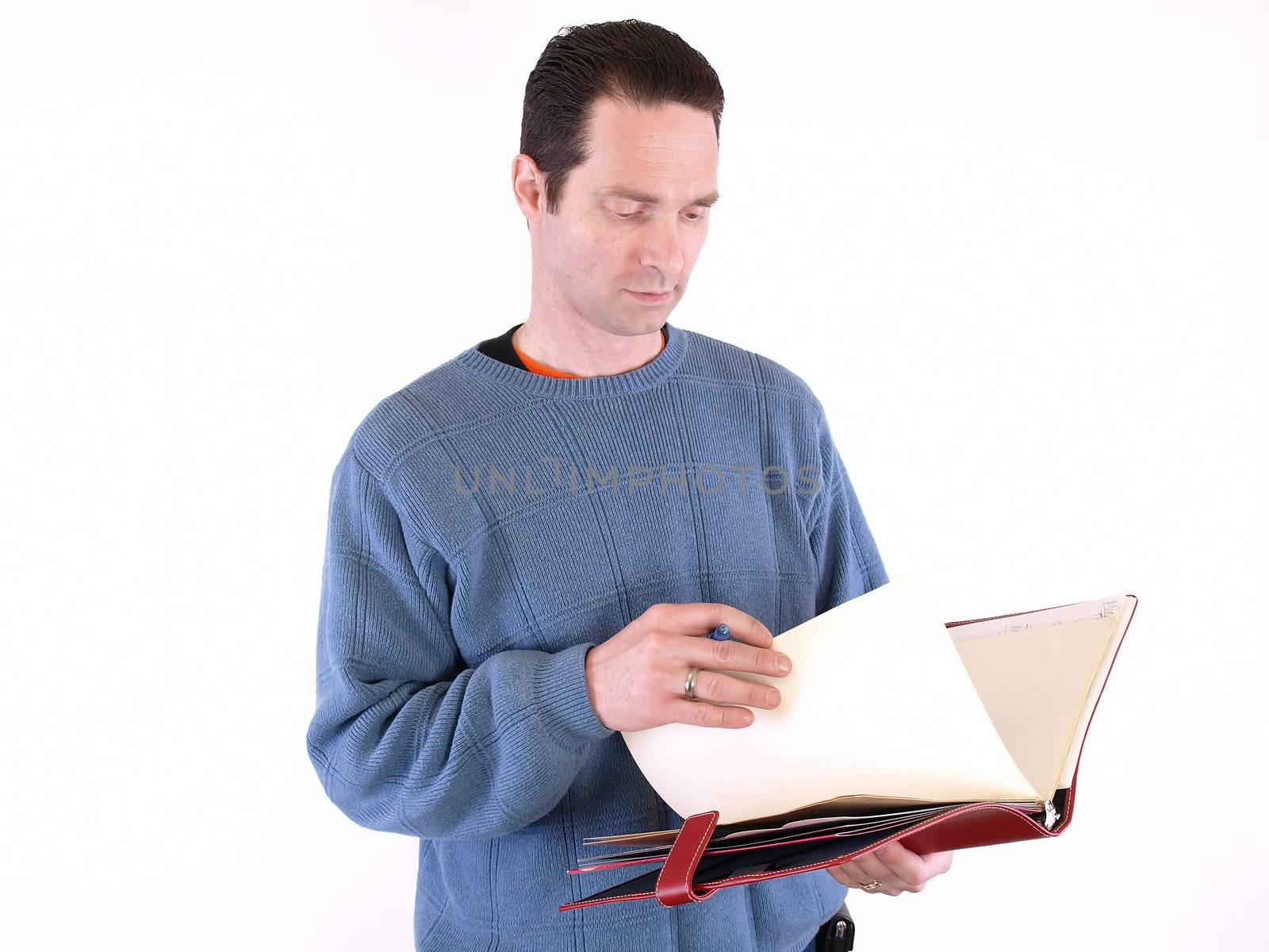 An adult male looking over notes in a binder, isolated against a white background.