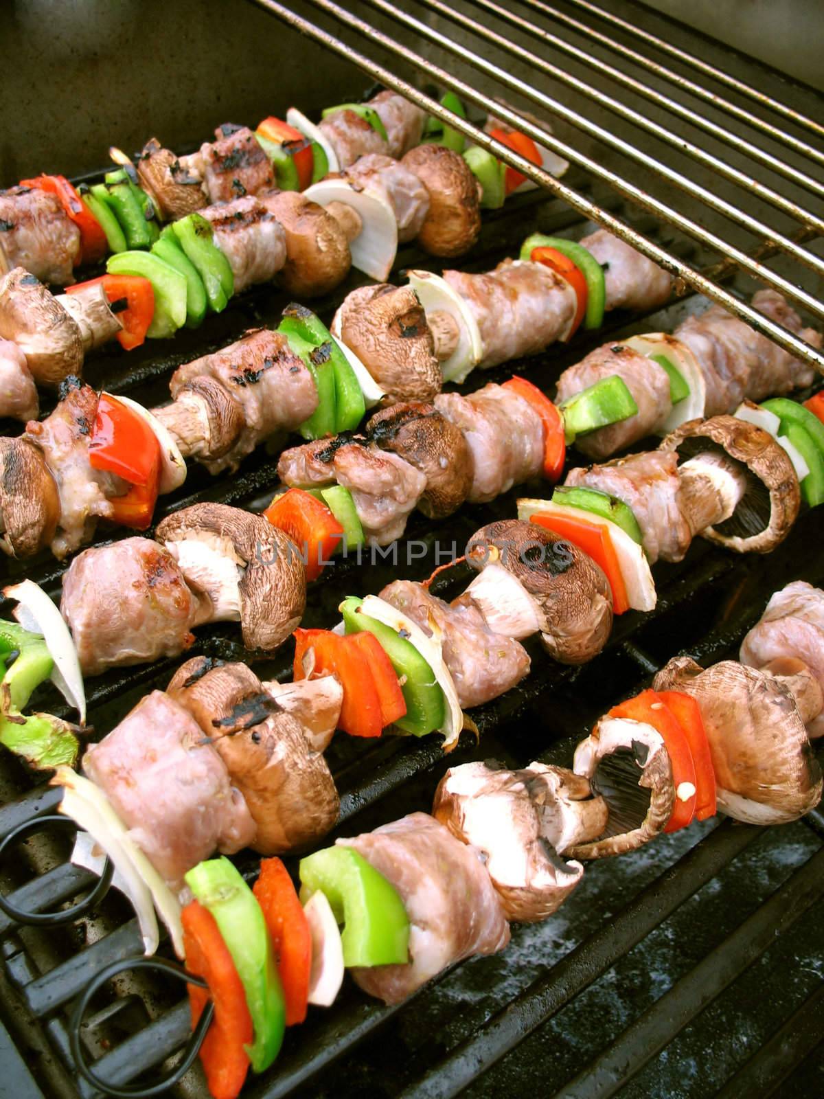 Sausage shish kebabs on skewers, cooking on the grill.  