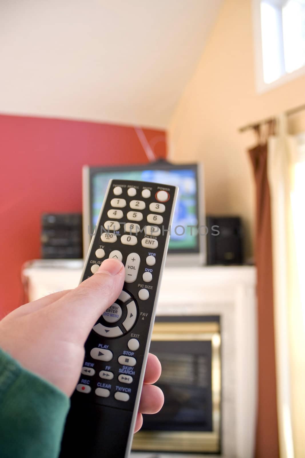 A remote control in hand - shallow depth of field with focus on the remote.