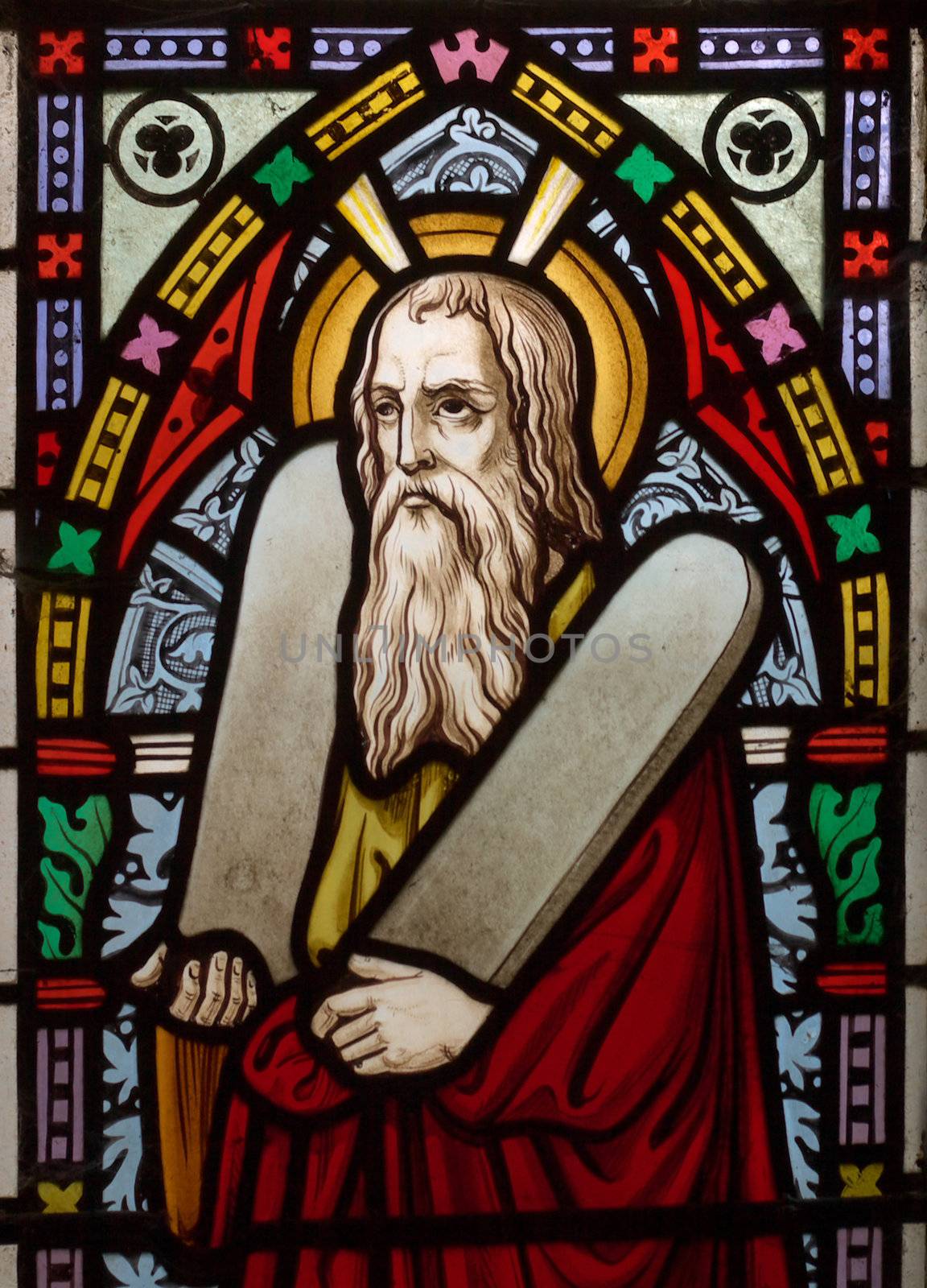detail of victorian stained glass church window in Fringford depicting Moses with the tablets of covenant in his arms, interestingly without text, means he is pictured before climbing Mount Sinai