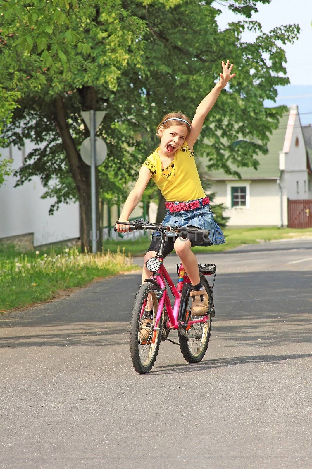 Beautiful young girl going with bike in front of the camera
