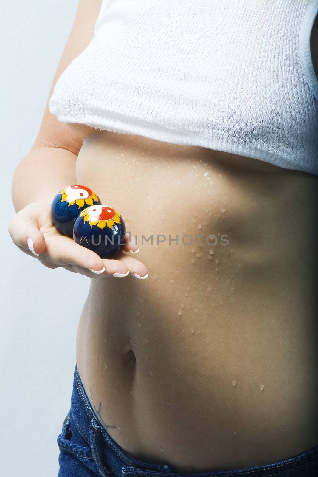 Beautiful model sweating holds chinese healing balls to relieve stess.