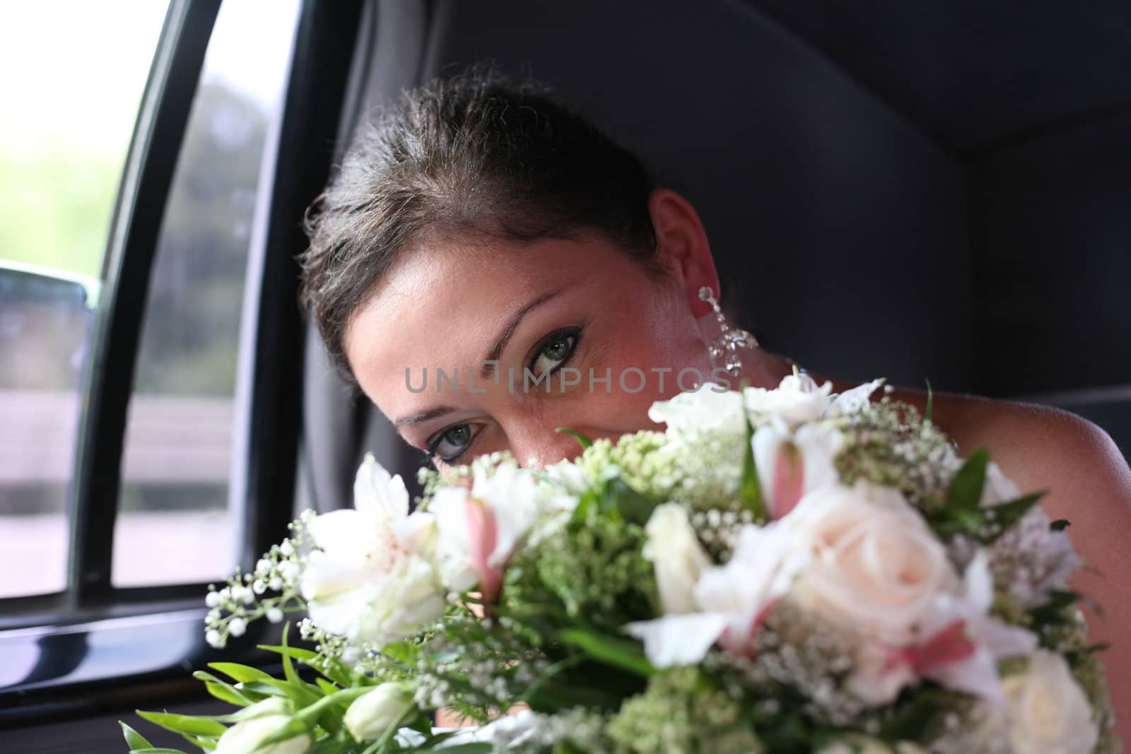 Beautiful the bride with a bouquet in the automobile
