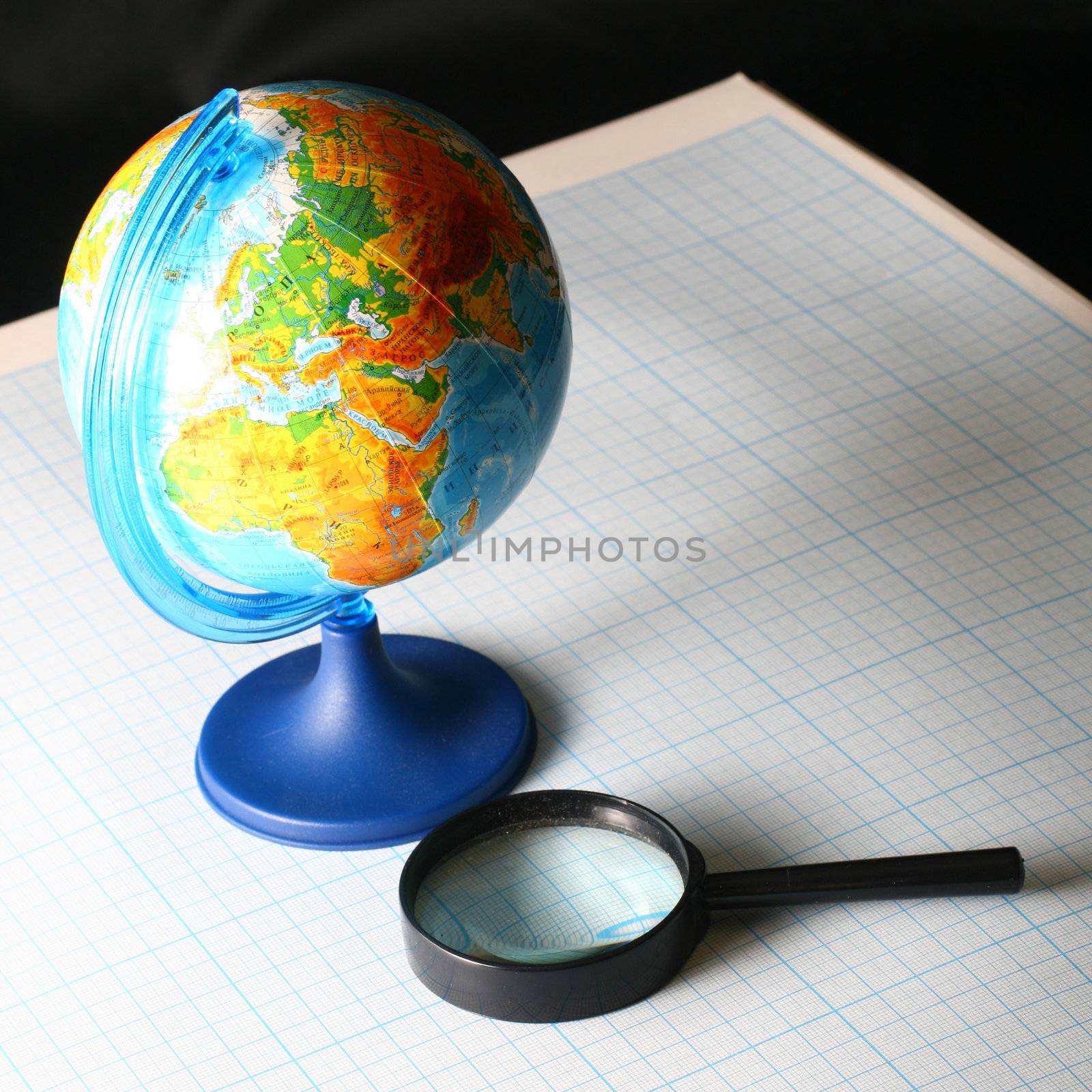 earth globe and magnifier in dark