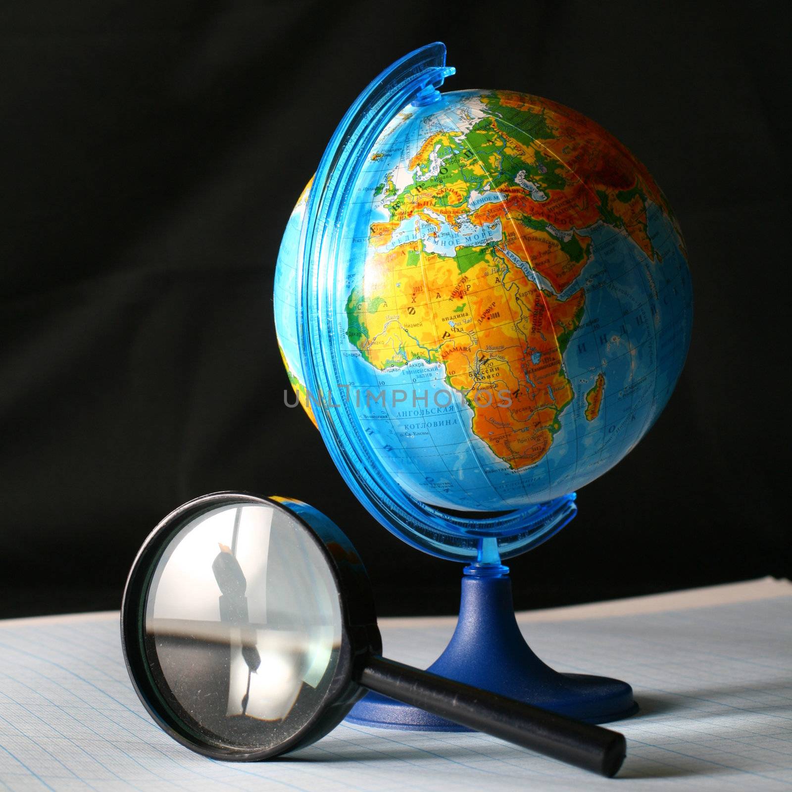 earth globe and magnifier in dark