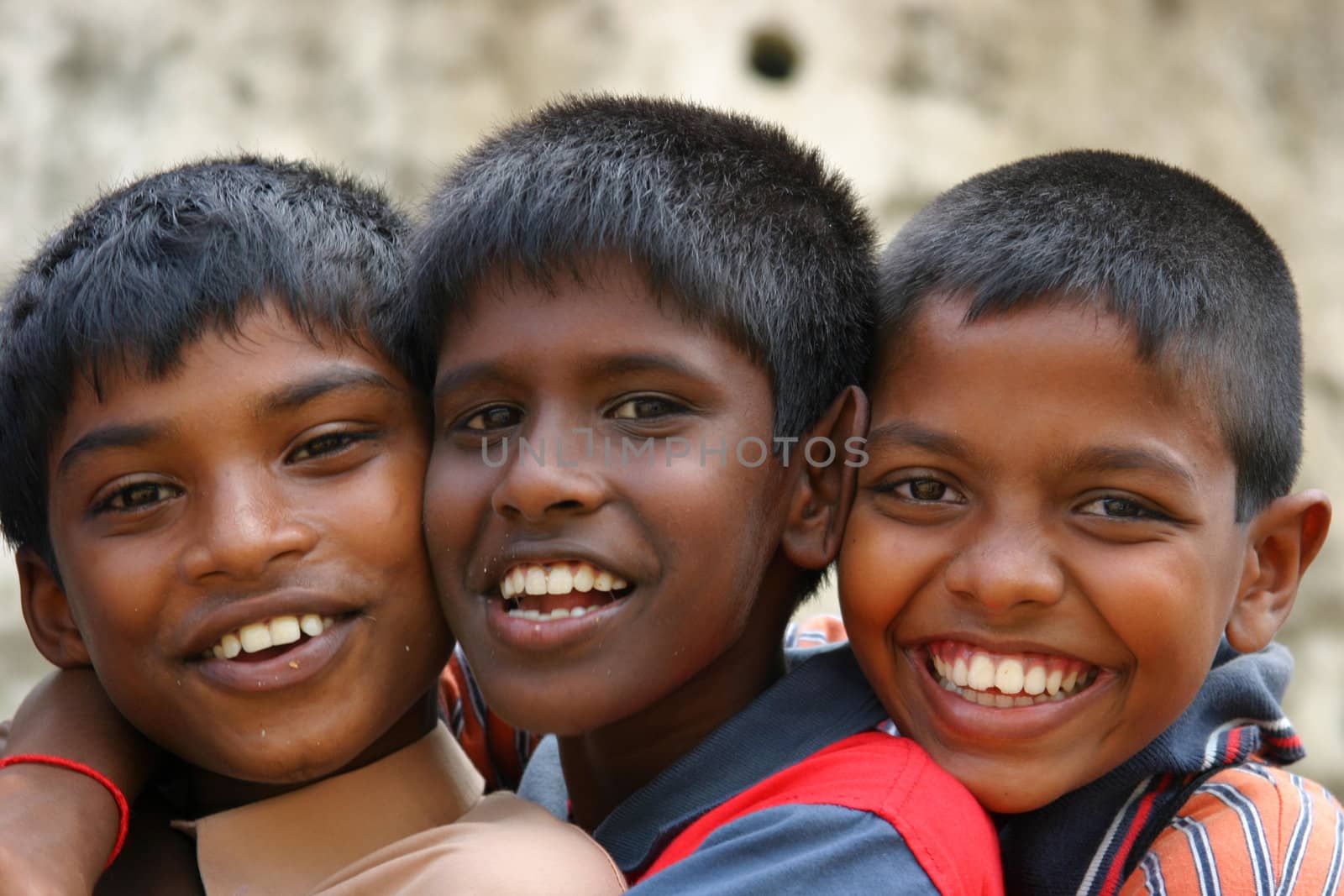 Three young schoolboys having fun posing for the camera, near Pinnawela, Sri Lanka