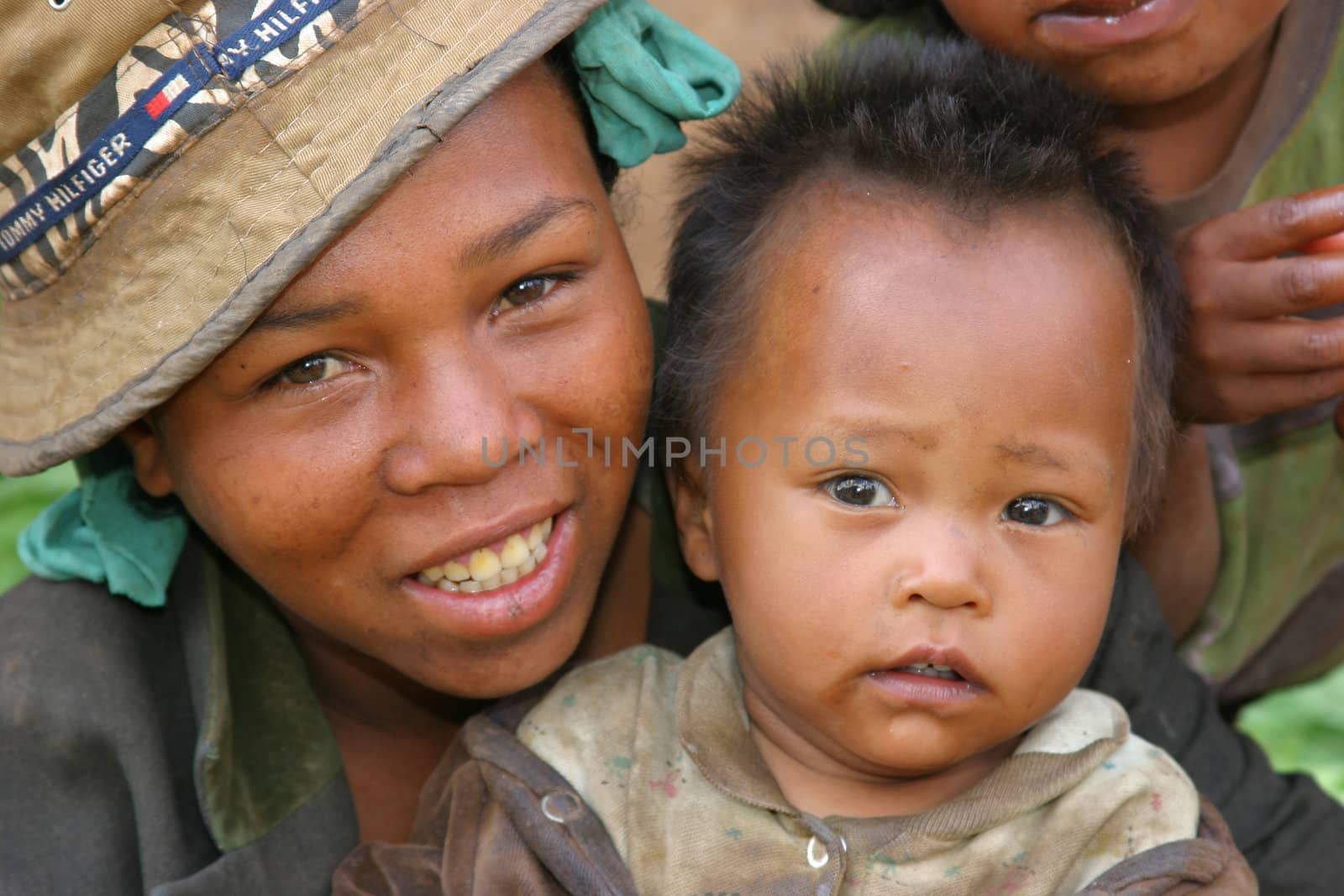 Very young mother with her son at a market smiling at the camera