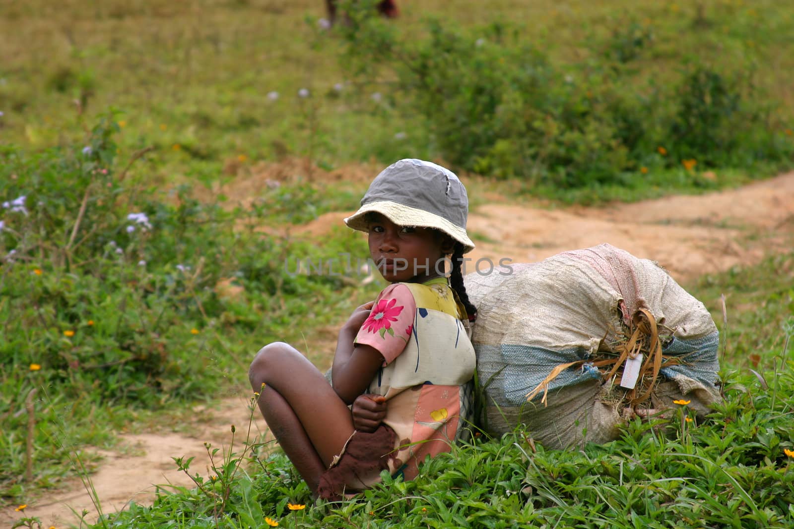 Pretty young girl sitting besides the road in Madagascar