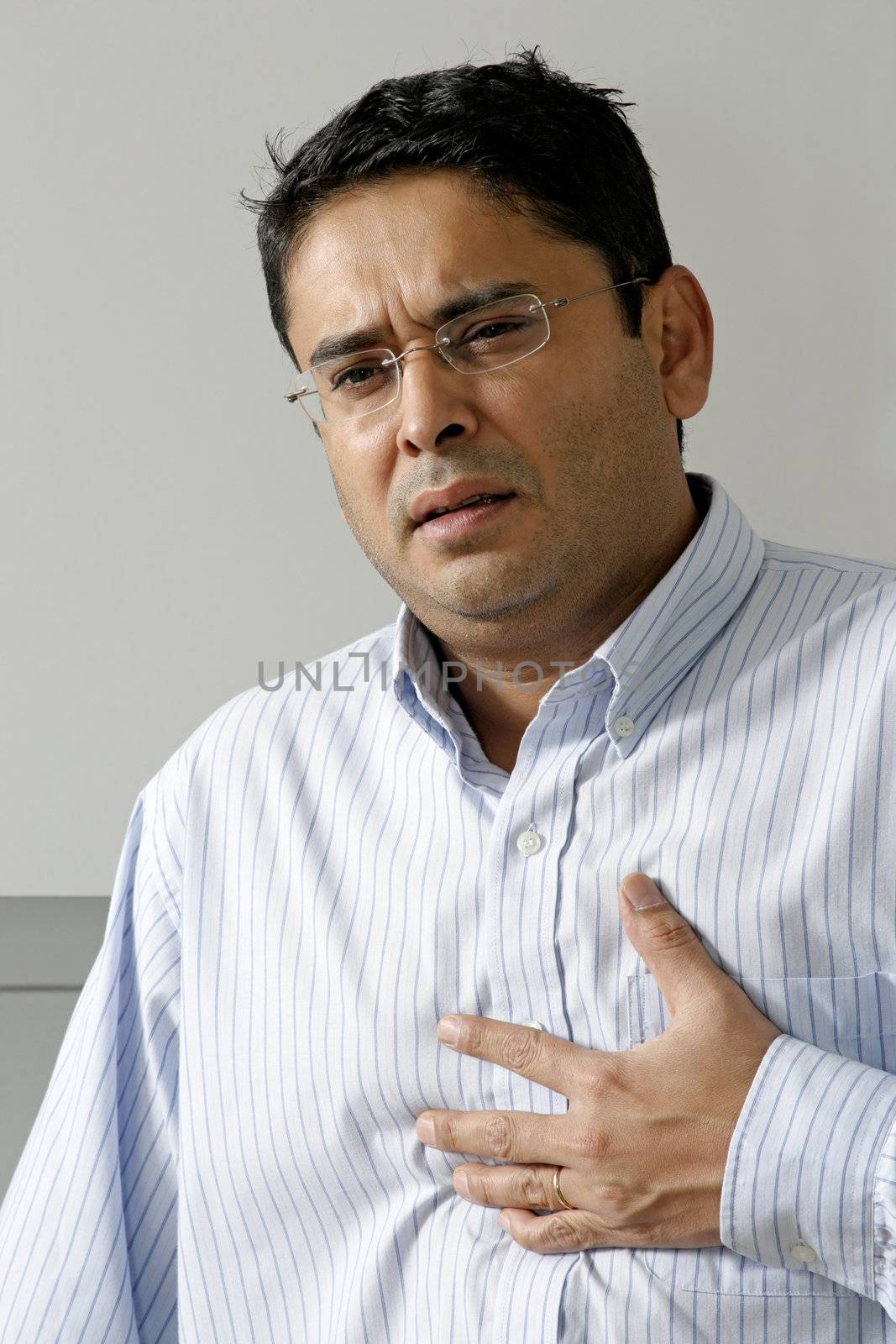 Man in his late thirties having a dose of heartburn or pains in his chest.
