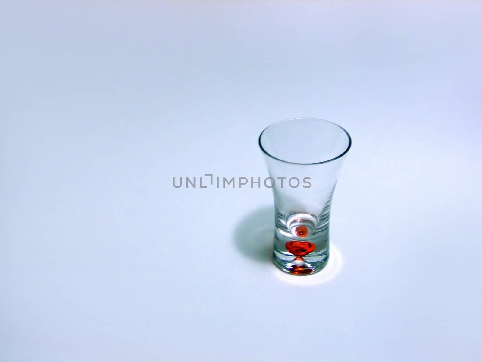 a single isolated shot glass over white