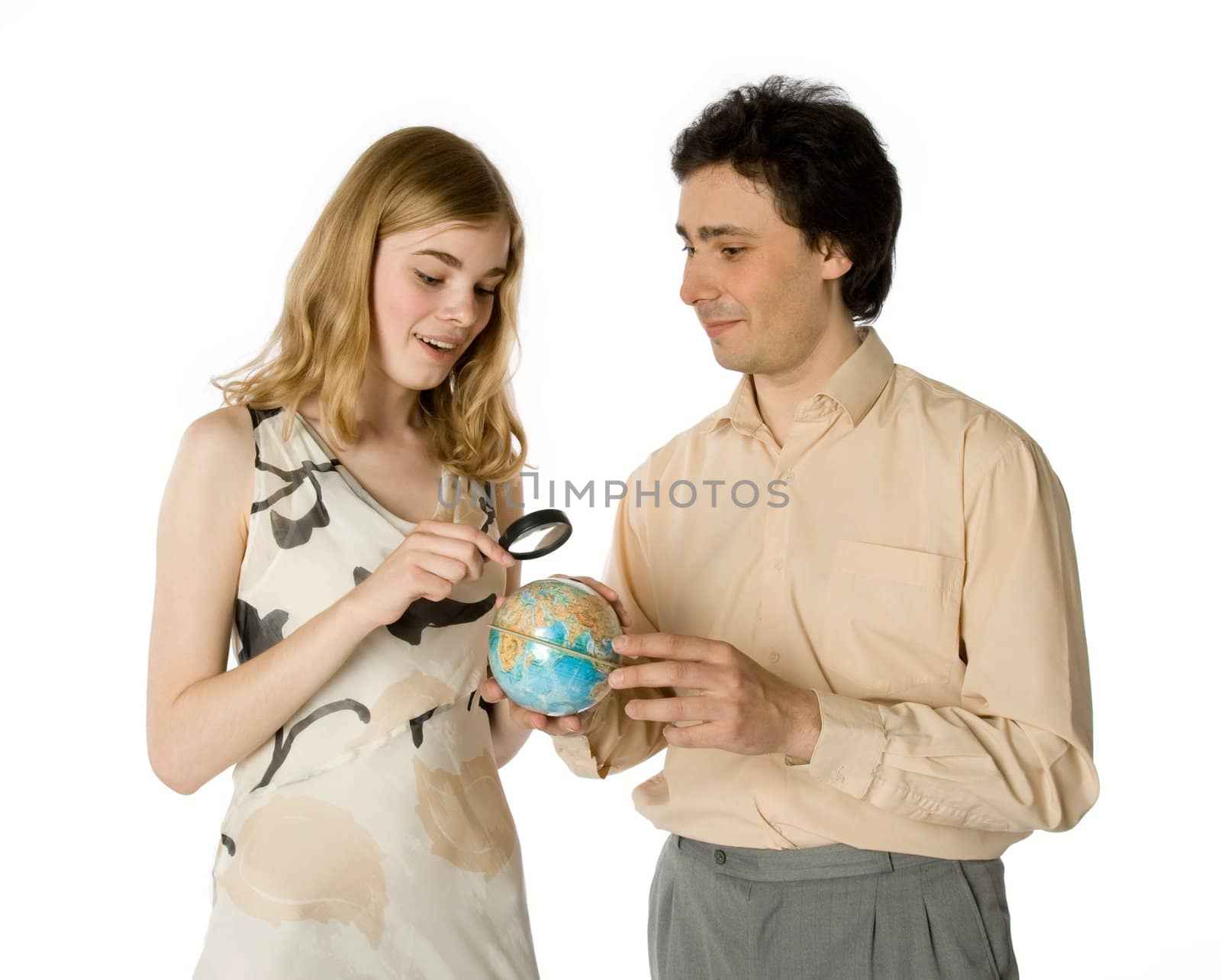 A couple looking at a small globe through a magnifier