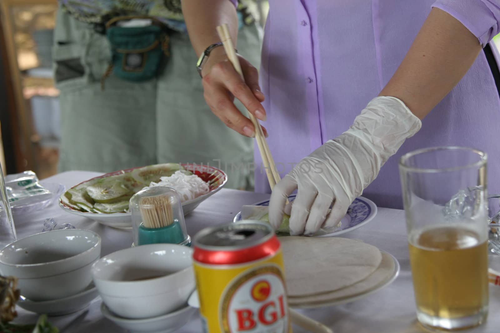 Waitress showing how to make an eggroll in Vietnam