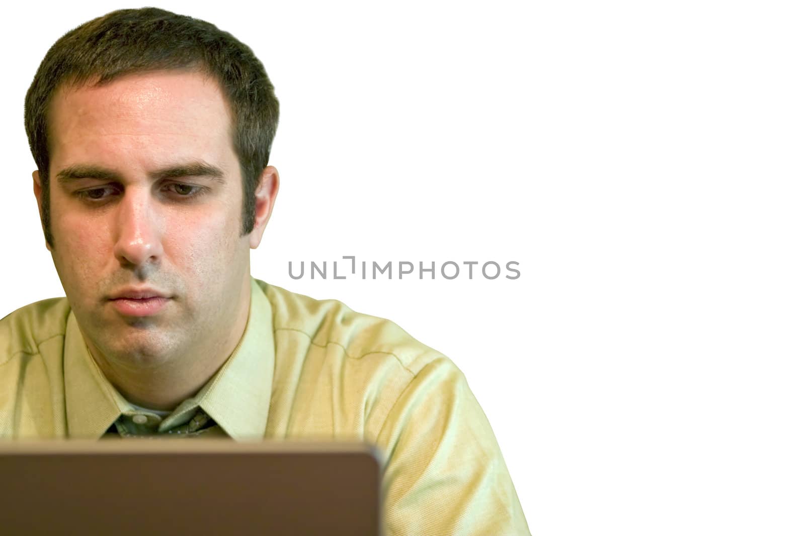 A young business man working from home on his laptop.  Plenty of copy space - image includes clipping path.
