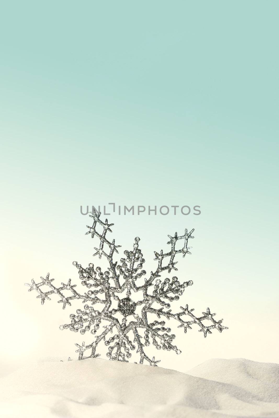 Sparkling snowflake in the snow with white background