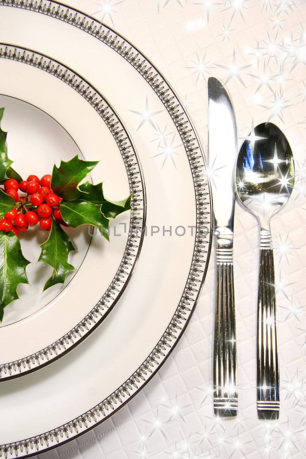 Silver plate setting with a sprig of holly and stars