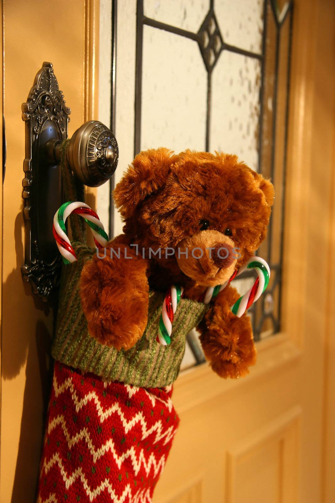 Teddy bear in stocking hanging on a door knob