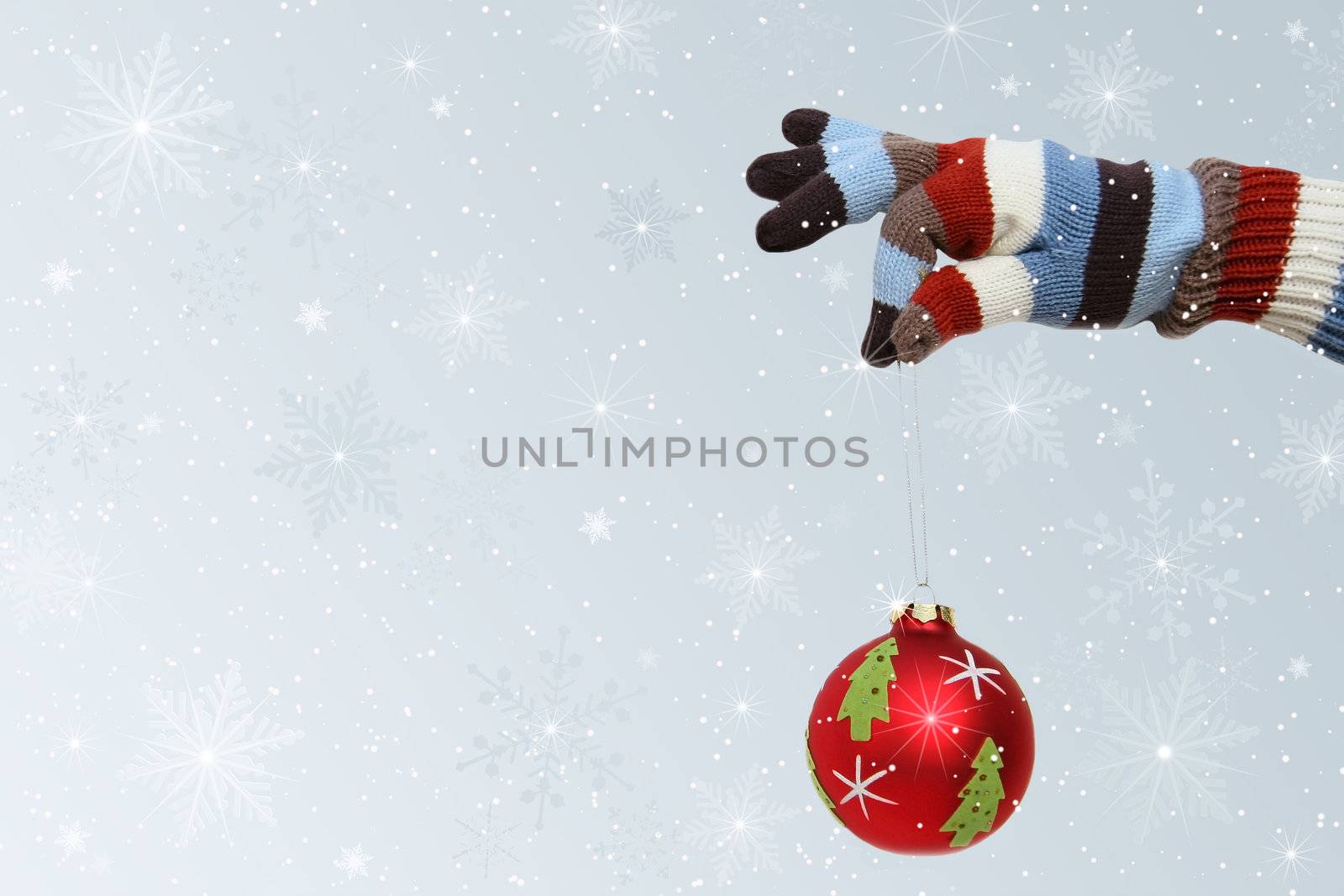 Winter mitten holding a Christmas ball