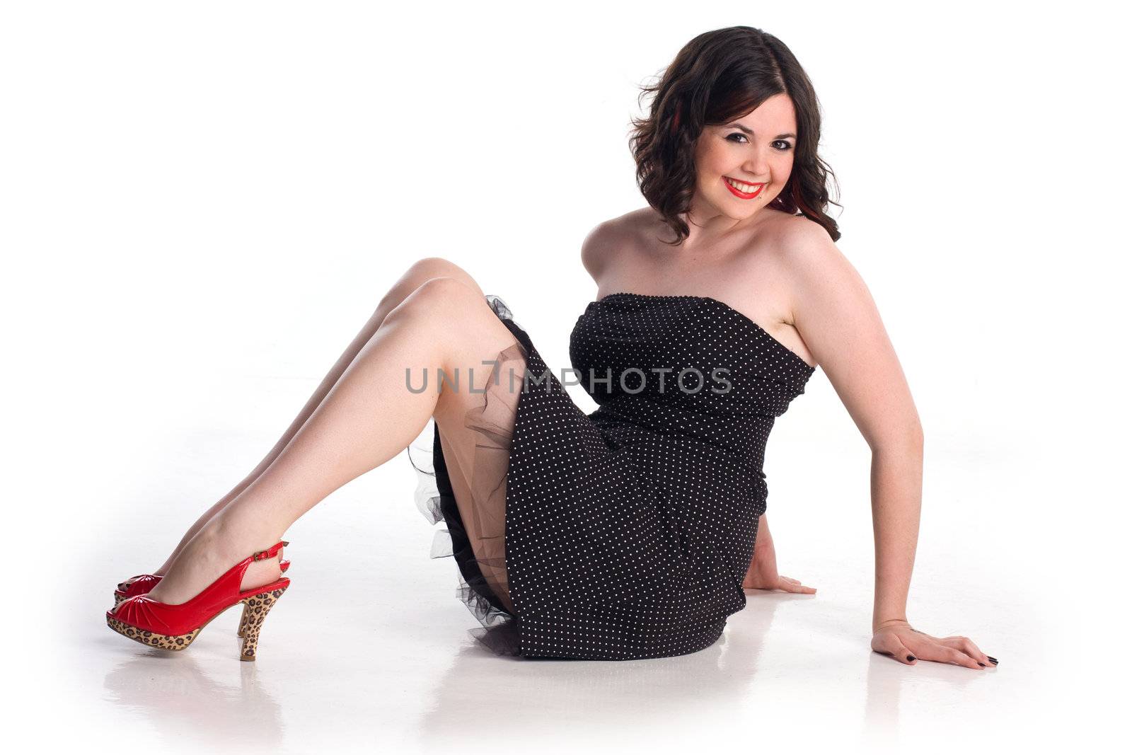Cute girl in pin-up pose in polka dot dress