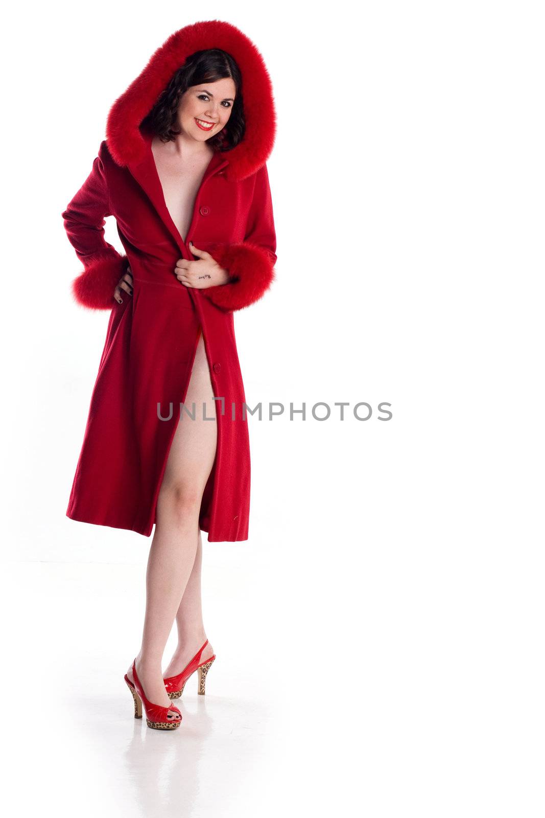 Cute girl in pin-up pose in red fur coat and heels