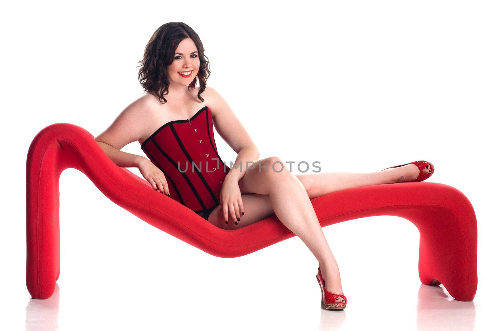 Cute girl in pin-up pose on red couch by krazeedrocks