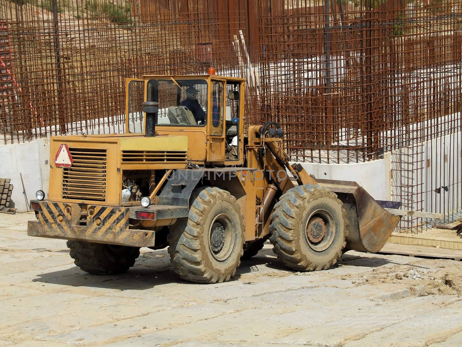 Front loader unloading concrete rubble on urban construction site