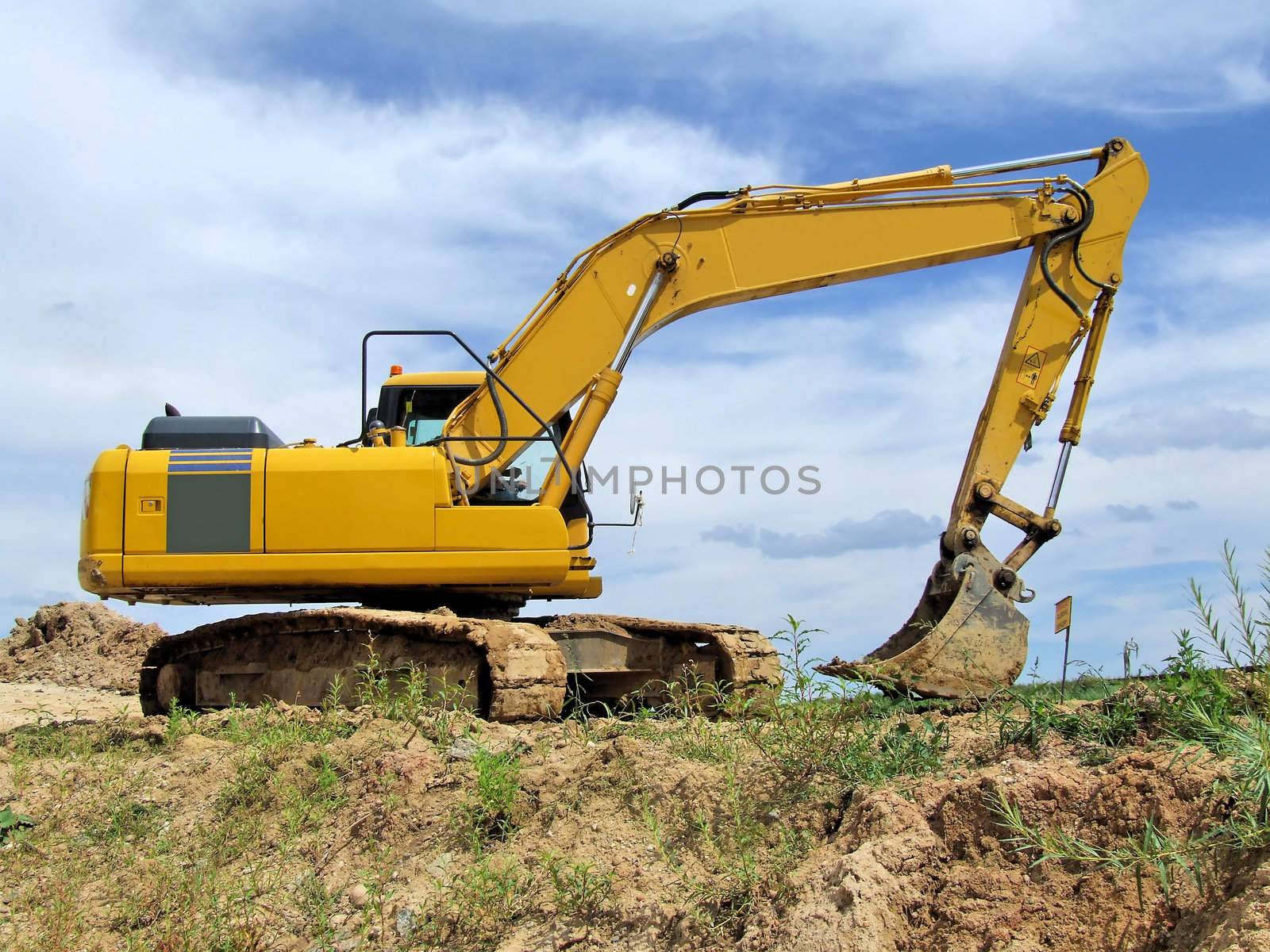 Yellow excavator at construction site by anki21