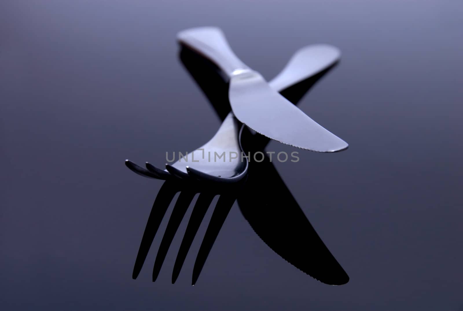 modern silver spoon, knife, fork on the mirror background by anki21
